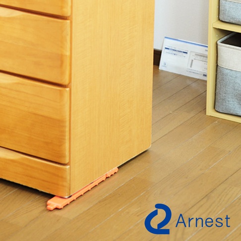 橙色長型迷你家具起重器，用於支撐木質抽屜櫃的底部，使其更容易移動。