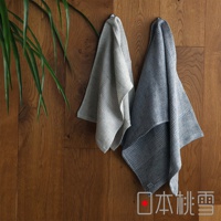 日本桃雪SEK抗菌防臭檜木鬆餅紋毛巾，兩條不同顏色的毛巾掛在木牆上，旁邊有一片綠葉植物