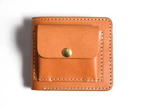 職人手作皮革雙折短夾，採淺棕色皮革製成，外附帶有金色金屬釦的零錢袋，整體縫線整齊。