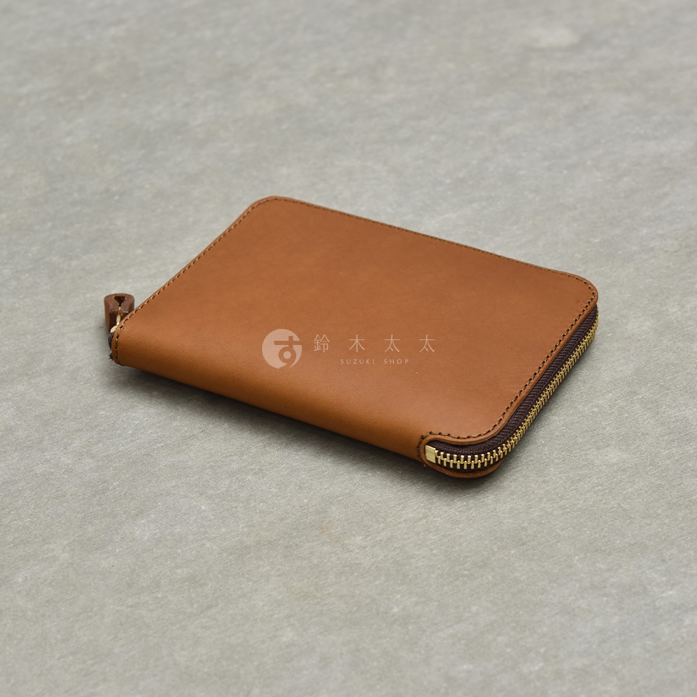 職人手作皮革Organ記事本收納包，展示了其精緻的縫線和金屬拉鍊細節，整體呈現溫潤的棕色皮革質感。