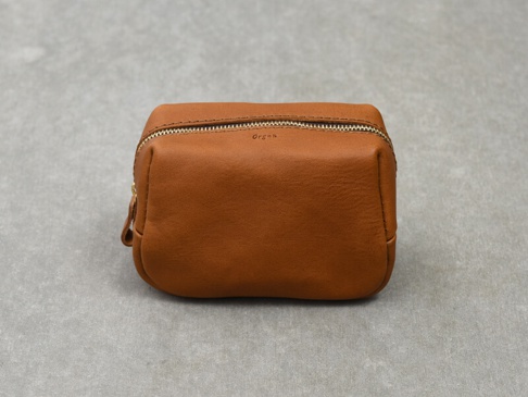 一個方形的咖啡色皮革拉鍊收納包，頂部有一條金屬拉鍊，包身上印有「Orga」字樣。