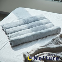 淺灰色毛巾枕，由柔軟的毛巾材質製成，呈現捲繞的紋理，平放在白色床單上。