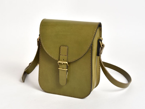 橄欖綠皮革迷你翻蓋單肩包，附有可調節肩帶和黃銅色金屬搭扣，採用手工縫製工藝。