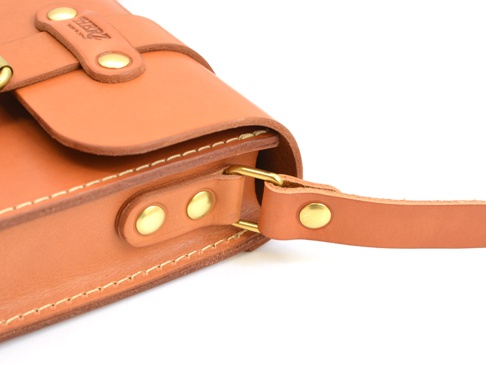 職人手作皮革經典皮扣單肩包 (CP-97)，採用天然棕色皮革製成，搭配黃銅色金屬扣件，展現經典復古風格。包身縫線清晰，質感優良。