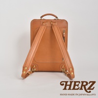 職人手作皮革商務電腦後背包 R-25，經典棕色，採用真皮材質，設計簡約，配有可調節的皮革肩帶、拉鍊隔層及品牌標誌。