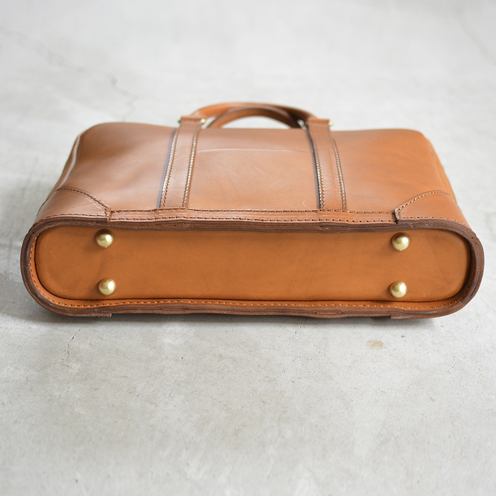 職人手作皮革Organ商務公事包，淺棕色皮革，經典公事包造型，頂部有提把，側面有四個黃銅腳釘，皮革邊緣縫線細緻。