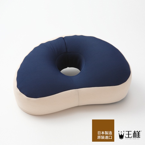 深藍色與米色拼接的王樣午睡枕，設有圓形開口，材質柔軟，適合午間休息使用。