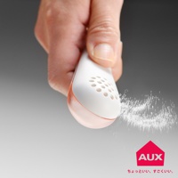 手持白色帶有橘色透明底部的鹽匙，頂部有圓形孔洞，正將白色細鹽均勻撒出。