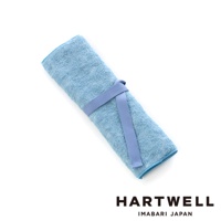 淡藍色毛巾材質的牙刷收納袋，以同色系織帶固定捲起，呈現簡潔的設計。