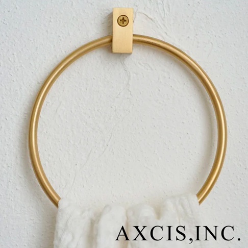 輕奢黃銅圓形毛巾環，以黃銅材質製成，呈現金色光澤，固定於白色紋理牆面，下方懸掛一條白色毛巾。