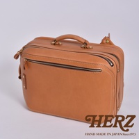 職人手作皮革兩用商務後背包 R-33，呈現原色皮革材質，具有頂部提把、雙拉鍊主袋、前方拉鍊口袋，以及側邊金屬扣件和皮革裝飾。