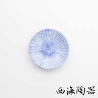 圓形白色瓷盤，盤面繪有藍色細緻放射狀線條，呈現十草紋，盤中央線條較密集，向外擴散。