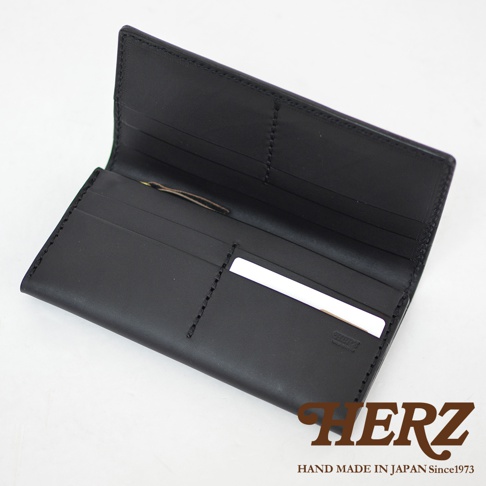 日本HERZ職人手作皮革長夾內部細節，全黑Latigo軟皮革材質，正面展示精緻的手工縫線與多層卡片收納夾層，右下方印有品牌壓紋，右下角附有HERZ品牌標誌與文字，整體呈現簡約耐用的質感。