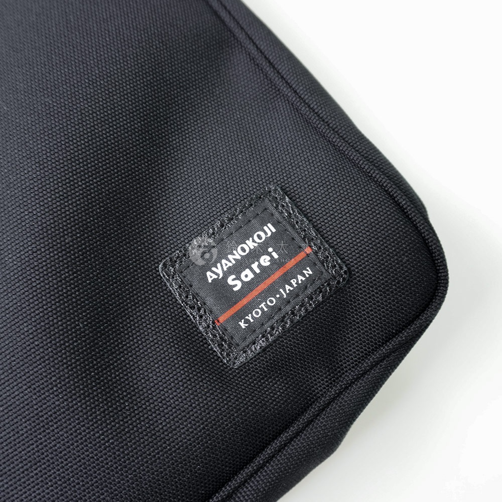 黑色的綾織布材質斜背包，上面有著「AYANOKOJI Sarei KYOTO JAPAN」字樣的品牌標籤。
