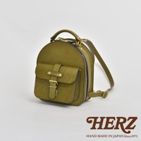 橄欖綠皮革迷你後背包，圓弧形設計，正面有一個帶有金屬釦帶的翻蓋口袋，側邊有拉鍊開合，頂部有提把，配有可調節的皮革肩帶。
