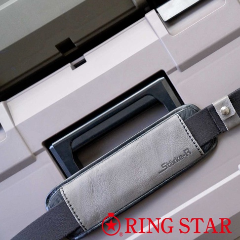 Stärke-R 進化超級箱的灰色皮革肩墊，帶有黑色織物背襯和金屬鈕扣，連接到灰色的箱體上，箱體有一個黑色嵌入式手柄。