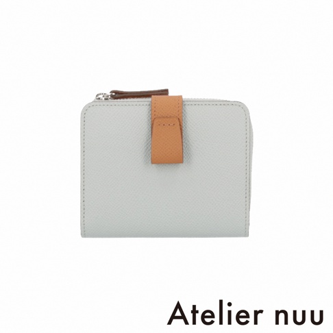 Atelier nuu 的 noble 系列皮革雙折短夾，採用霧灰色壓紋皮革製成，中央搭配棕色皮革垂直扣帶，上方為銀色 L 型拉鍊設計，展現簡約質感的時尚風格。