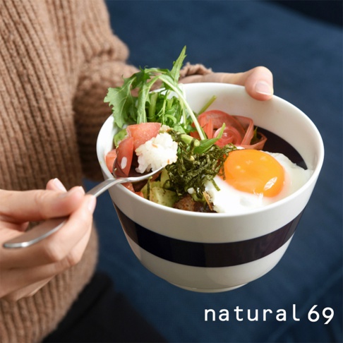 海軍風條紋丼碗，白色碗身帶有兩條深藍色寬條紋，碗內盛有米飯、半熟荷包蛋、酪梨、番茄及綠葉蔬菜，由手持湯匙的人捧著。