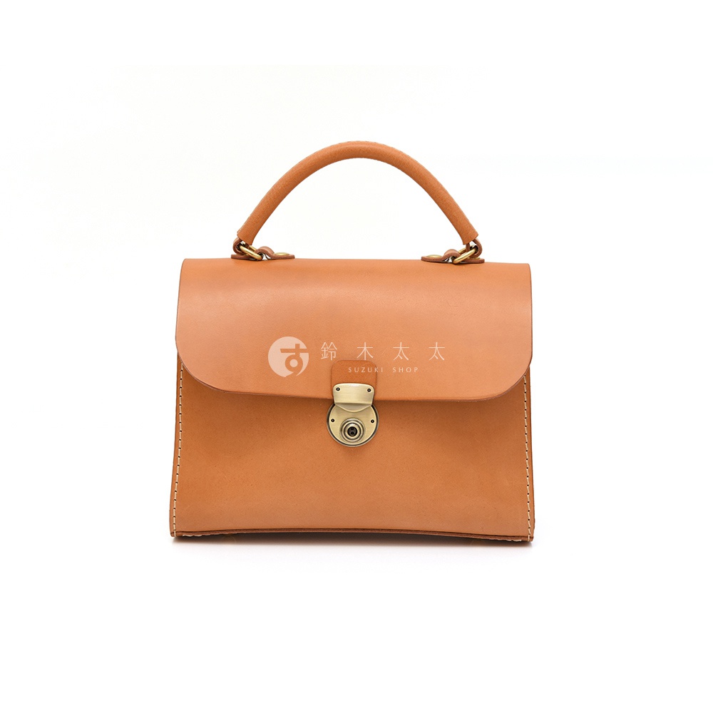 日本HERZ職人手作皮革多功能收納單肩包，駝色圓潤提把搭配金色鎖扣，前方印有SUZUKI SHOP日文Logo。