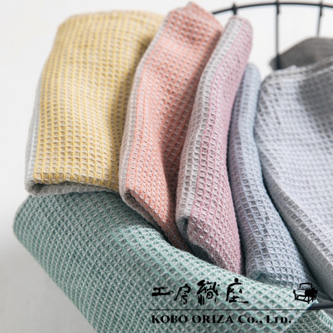WAFLE 棉麻混紡拭巾，具備鬆餅格紋織法，展現柔和的雙色設計。圖片中的拭巾顏色包含黃色、珊瑚粉、淡粉色、淺藍色和灰色，材質觸感細緻，適合居家使用。