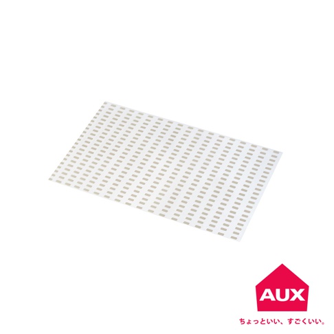 一張白底上，一張淺米色的多功能砧板防汙紙，表面佈滿規則的長方形小孔，呈現網格狀，紙張邊緣平整。右下角有一個紅色屋頂形狀的標誌，內部寫有白色字母 AUX。