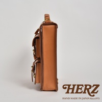 職人手作皮革三口袋三用後背包，側邊視角，展示淺棕色皮革材質、雙層前袋設計及金屬扣環。