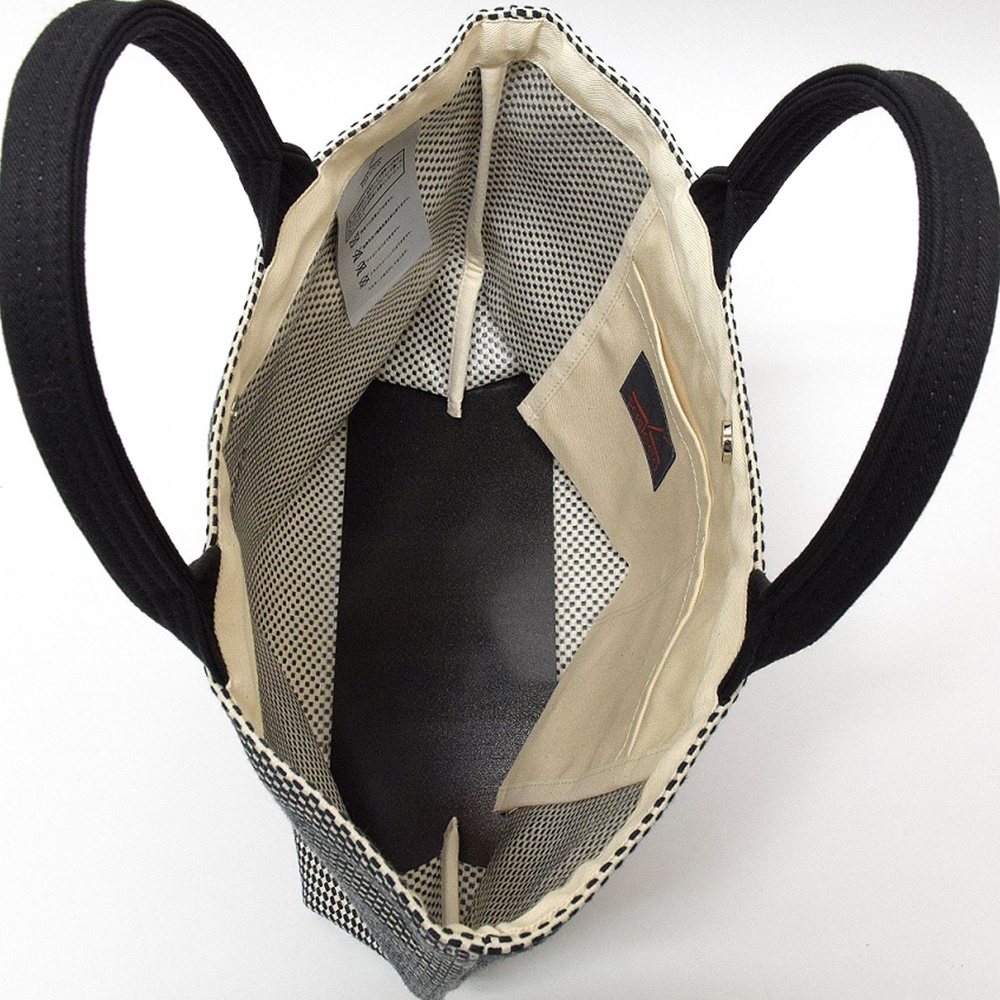 三河木綿刺子織經典托特包，黑色織帶提把，包內為米白色帆布內襯，設有黑色內袋及多個隔層，其中一個隔層上有紅色品牌標籤。