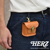 淺棕色皮革耳機收納包，附有金色金屬扣和登山鉤，可掛於牛仔褲上。