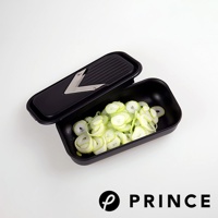 黑色的磨泥切片兩用盒，盒內盛有切片的蔥段，盒蓋上設有V型金屬刀片。