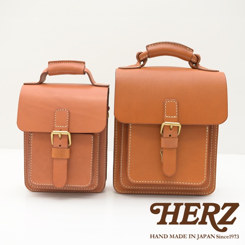 兩款棕色皮革單肩兩用小方包，均有翻蓋設計、金屬扣環及皮革束帶，以白色背景呈現。