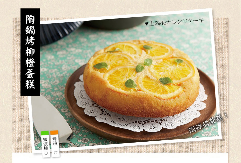 陶鍋烤柳橙蛋糕，金黃色澤的蛋糕體鋪滿了新鮮橙片，點綴著幾片翠綠的薄荷葉，盛放在木質盤上，下方襯有白色蕾絲紙墊。