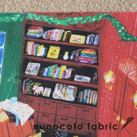 無框帆布藝術海報，描繪聖誕老人玩具工作室場景，有滿架色彩繽紛的書本、一個白色聖誕老人玩偶，以及一個牽著紅色小精靈的白色山羊，背景是綠色聖誕樹藤蔓裝飾的紅色牆壁。