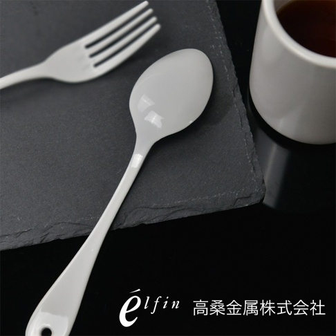 日製白琺瑯餐匙，一組兩入，勺頭圓潤，勺柄帶有掛孔，材質光滑反光，搭配黑色石板和白色杯子。