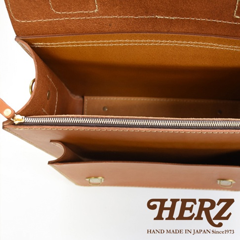 職人手作皮革經典雙扣兩用單肩包，咖啡色皮革，內部有拉鍊隔層，外部有兩個金屬扣。