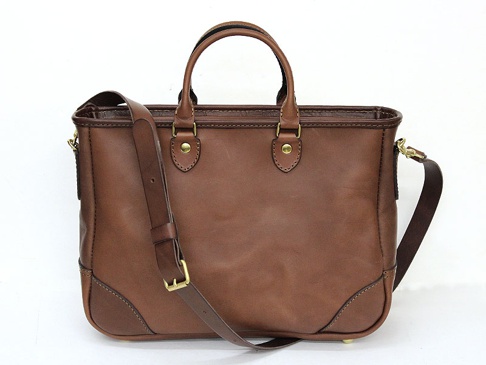 職人手作深棕色皮革兩用商務托特包，配有頂部提把和可拆卸斜背包帶，包身結構方正，底部有金屬腳釘，整體呈現經典復古風格。