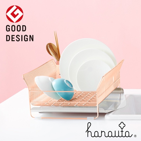 玫瑰金色不鏽鋼碗碟架，附有瀝水盤，架上擺放著白色盤子、藍色與白色碗，以及木製筷子和湯匙。