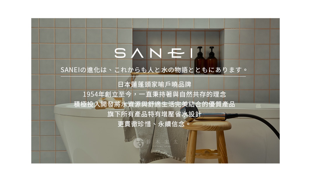 銀色金屬材質的蓮蓬頭，配有黑色軟管，放置在木製凳子上，背景為淺灰色磁磚牆壁和白色浴缸。