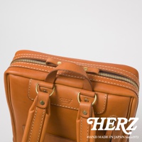 職人手作皮革軟皮商務後背包，採用棕褐色皮革，搭配黃銅色拉鍊與釦件，車縫線明顯，質感細膩。