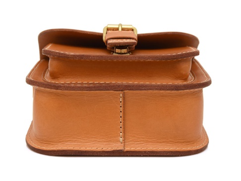 淺棕色皮革製成的單肩包，具有翻蓋和金色搭扣，邊緣有精緻的縫線裝飾，展現職人手作質感。