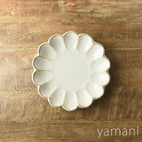 淺白色陶瓷六瓣花型主食盤，帶有粉引釉色，置於木紋桌面。