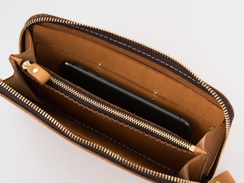 職人手作皮革大容量拉鍊長夾 (WL-5)，打開的長夾內部，展現溫暖的棕色皮革、金屬拉鍊和一個黑色手機。