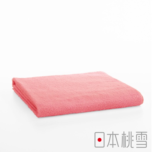 一條珊瑚粉色、觸感柔軟的飯店大毛巾，採用厚實的棉質材質，呈現蓬鬆的毛圈質感，局部可見毛巾摺疊的邊緣。