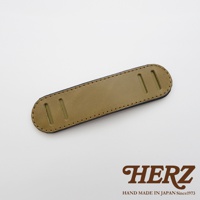 職人手作皮革肩墊，呈現大地色系皮革表面，搭配深色縫線與兩側長形開口，適合搭配各式包款。