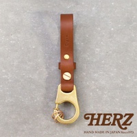 一款棕色皮革鑰匙圈，上方壓有「Organ」字樣，搭配黃銅色掛鉤和固定零件，整體設計簡潔實用。