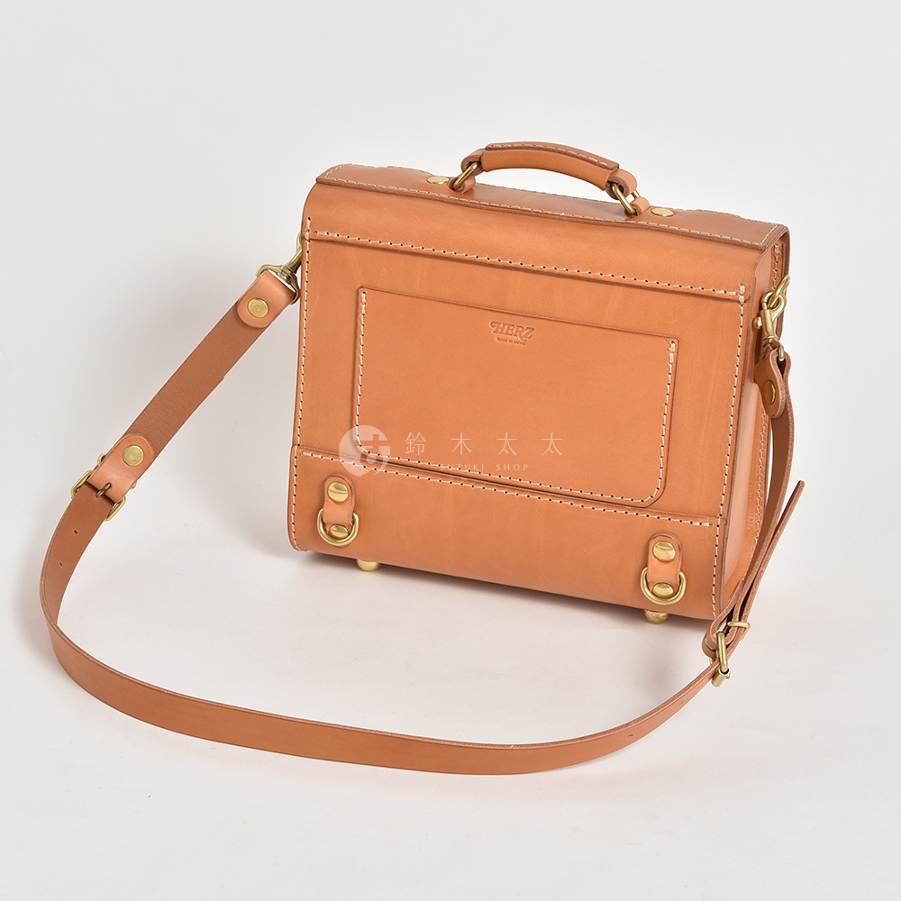 職人手作皮革學院風三用迷你後背包，淺棕色皮革，配有可調節的皮革背帶，包身結構方正，側面有金屬扣環，正面有品牌壓印和收納隔層。