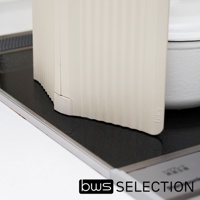 米色六片式摺疊隔板，表面有垂直紋路，置於爐灶黑色防油墊上，右側為白色鍋具。