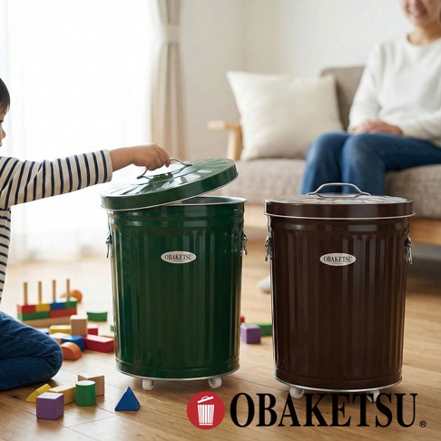 OBAKETSU 品牌綠色和棕色附輪垃圾桶，一個由男孩正在開蓋，周圍散落著積木。