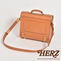 皮革學院風三用迷你後背包，顏色為淺棕色，包身以堅固的皮革製成，配有可調整的肩帶和頂部提把，正面有立體口袋和金屬釦環。