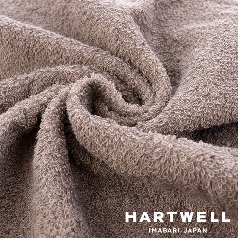 今治柔彈低摩擦美髮半浴巾，細膩柔軟的紋理，呈現柔和的灰褐色調，材質輕盈，觸感舒適。