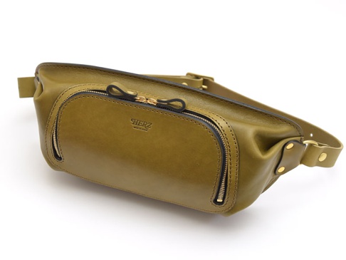 橄欖綠皮革拉鍊旅行斜背包，正面有兩個拉鍊口袋，中央有品牌標誌。